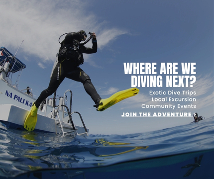 A diver doing a giant strike off a dive boat.